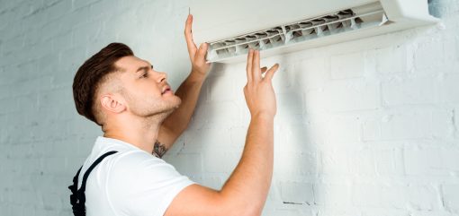 handsome installer looking at air conditioner